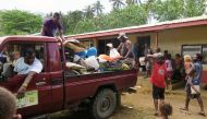 Residents who were evacuated due to the Manaro Voui volcano, look on as food is delivered to them at an evacuation center set up at the Ambae Bulu junior secondary school located in east Ambae, on Vanuatu's northern island of Ambae in the South Pacific, O