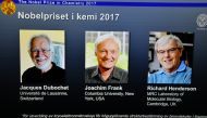 (L-R) Photos of the winners of the Nobel Prize in Chemistry Jacques Dubochet, Joachim Frank and Richard Henderson are seen on a screen as Secretary General of the Royal Swedish Academy of Sciences Goran K. Hansson (not seen) announces the winner of the 20