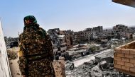 A member of the Syrian Democratic Forces (SDF), backed by US special forces, monitors the area on the western frontline in Raqa on October 8, 2017.  AFP / BULENT KILIC
