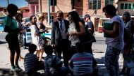 Teachers and social workers who are part of a team for inclusion of children and students in the educational system, talk with children in the Roma neighbourhood of Stolipinovo in the city of Plovdiv on September 13, 2017. AFP / Dimitar DILKOFF

