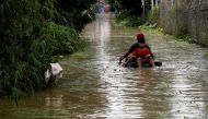 Boys paddle an improvised boat in a flooded village after a tropical depression in Hanoi, Vietnam October 13, 2017. REUTERS/Kham.
