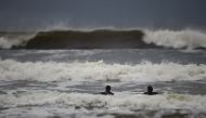Surfers watch as waves approach in the Atlantic on the eve of storm Ophelia in an area where the tide should be out in the County Clare town of Lahinch, Ireland October 15, 2017. REUTERS/Clodagh Kilcoyne
