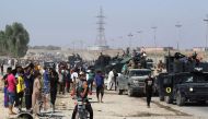 Iraqis gather as Iraqi forces arrive in the first neighbourhood on the southern outskirts of Kirkuk on October 16, 2017.  AFP / AHMAD AL-RUBAYE
