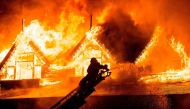 A firefighter extinguishes a fire at Kandawgyi Palace hotel in Yangon early on October 19, 2017. AFP / YE AUNG THU