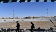 A member (L) of the Syrian Democratic Forces (SDF) inspects the municipal stadium in Raqa on October 18, 2017, after the US-backed forces retook the city from Islamic State (IS) group fighters.   AFP / BULENT KILIC
