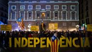 This file photo taken on December 27, 2016 shows Catalan pro-independence supporters holding Catalan pro-independence flags and letters reading 