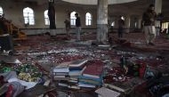 Afghan residents look inside the Imam Zaman Shiite mosque which was a the site of a suicide attack during evening prayers, in Kabul on October 21, 2017. AFP / WAKIL KOHSAR
