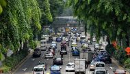 Motorists enter the financial district area in Singapore on October 24, 2017. Singapore, one of the most expensive places in the world to buy a vehicle, has announced it will freeze the number of private cars on its roads from next year but vowed to expan