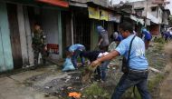 A soldier walks past members of the local government as they clear the area inside a war-torn Marawi city, southern Philippines October 19, 2017. REUTERS/Romeo Ranoco.