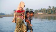 A Rohingya refugee family walks through water after crossing the Bangladesh-Myanmar border, at a port in Teknaf, Bangladesh October 25, 2017. REUTERS/Adnan Abidi
