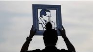 A woman holds the portrait of Thailand's late King Bhumibol Adulyadej as mourners wait for tomorrow's Royal Cremation ceremony near the Grand Palace in Bangkok. (Photo: REUTERS/Damir Sagolj).