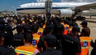 A file photo of Chinese nationals (in orange vests) who were arrested over a suspected internet scam, are escorted by Chinese police officers before they were deported at Phnom Penh International Airport, in Phnom Penh, Cambodia, October 12, 2017. REUTERS