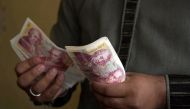 A file photo of  a Pakistani Kashmiri foreign currency dealer counting British pound notes at a remittance shop in the Pakistani Kashmir city of Mirpur, which is known as 