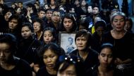 A mourner pray for the late Thai King Bhumibol Adulyadej during the procession transferring the relics and his ashes from the Grand Palace to a local temple in Bangkok on October 29, 2017. AFP / YE AUNG THU
