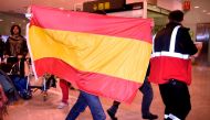 A person holds a Spanish flag at El Prat airport in Barcelona where some members of the dismissed government of Catalonia arrived from Brussel on October 31, 2017.