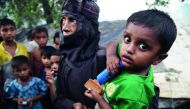 Rohingya Muslim refugee Fahima Bibi, 56, carries her grandson Mohammad Jabed, 2, as she walks back to their tent at Kutupalong refugee camp in the Bangladehsi distrcit of Ukhia on November 3, 2017. AFP / Dibyangshu Sarkar