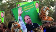 A supporter of the ruling Pakistan Muslim League (Nawaz) (PML-N) holds a picture of Nawaz Sharif outside the accountability court where he appeared to face corruption charges filed against him, in Islamabad, Pakistan November 3, 2017. Reuters/Faisal Mahmo