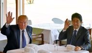 US President Donald Trump (L) and Japanese Prime Minister Shinzo Abe (R) wave to reporters after they signed hats reading 'Donald and Shinzo, Make Alliance Even Greater' at the Kasumigaseki Country Club in Kawagoe, Japan on November 05, 2017. Anadolu Agen