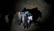A file photo of a wounded Syrian man being carried on a mule as they approach a meeting point with Israeli soldiers on Mount Hermon in the Israeli-annexed Golan Heights on the border line between Israel and Syria, before being transferred to an Israeli ho