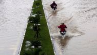 People ride motorcycles along flooded road after typhoon Damrey hits Vietnam in Hue city, Vietnam November 5, 2017. REUTERS/Kham.