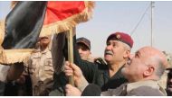 Iraqi Prime Minister Haider al-Abadi (R) hangs an Iraqi flag during his visit Qaim town and Husaybah border gate, newly-liberated town from IS terrorists, in Anbar, Iraq on November 5, 2017. ( Iraq Prime Ministry Press Office - Handout - Anadolu Agency ).