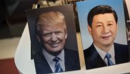 Framed photographs of Chinese President Xi Jinping (R) and US President Donald Trump are seen on display in a photo shop in Beijing on November 6, 2017. Donald Trump arrives in China on November 8, which is the third stop of his tour in Asia. / AFP / FRED