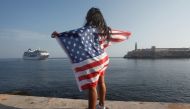 A woman with a US flags looks at the arrival of US Carnival cruise ship Adonia at the Havana bay, May 2, 2016 (Reuters) 