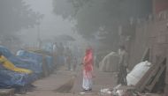 An Indian sweeper cleans a road amid heavy smog in New Delhi on November 8, 2017.  AFP / SAJJAD HUSSAIN
