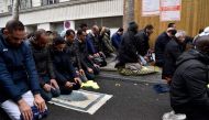 People pray in a street on November, 10, 2017, in Clichy, near Paris, while the city mayor Remi Muzeau, demonstrate with others political leaders against muslims streets prayers. AFP / Alain Jocard