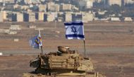 An Israeli flag flutters above the wreckage of an Israeli tank sitting on a hill in the Israeli-occupied sector of the Golan Heights on October 18, 2017 (AFP / Jalaa Marey) 