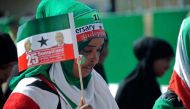 This file photo taken on May 18, 2016 shows a woman holding a flag as soldiers and other military personnel of Somaliland march past during an Independence day celebration parade in the capital, Hargeisa. The country will hold elections on Monday. PHOTO |