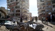  People inspect the debris of buildings and a destroyed vehicle at Sarpol-e Zahab province of Kermanshah, Iran on November 13, 2017 following a 7.3 magnitude earthquake that hit the Iraq and Iran. Anadolu Agency/ Fatemeh Bahrami