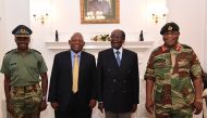 This screengrab from Zimbabwe Broadcasting Corporation (ZBC) taken on November 16, 2017, shows Zimbabwe President Robert Mugabe (2R) as he poses alongside Zimbabwe Defence Forces Commander General Constantino Chiwenga (R) and South African envoys at State