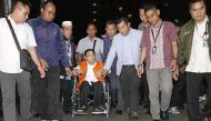 This picture taken on November 19, 2017 shows Parliament speaker Setya Novanto (in orange) being escorted by officials from the Corruption Eradication Commission (KPK) in Jakarta. / AFP.