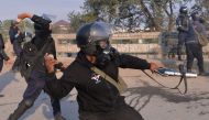 A Pakistani riot policeman throws a rock toward protesters of the Tehreek-i-Labaik Yah Rasool Allah Pakistan (TLYRAP) religious group during a protest in Islamabad on November 25, 2017. AFP / AAMIR QURESHI
