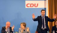 German Chancellor and leader of the Christian Democratic Union (CDU) party, Angela Merkel (C), applauds beside regional chairman Vincent Kokert (R) during a regional party conference in her home state of Mecklenburg Western Pomerania, in her first major a