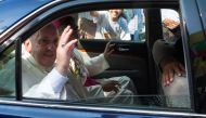 Pope Francis waves to well-wishers as he is driven through the streets of downtown Yangon on November 27, 2017. Pope Francis arrived in mainly Buddhist Myanmar on November 27 where he was set to meet army chief Min Aung Hlaing, the man accused of overseei