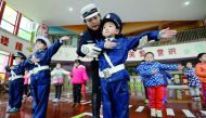 In this picture taken on November 29, 2017, a traffic warden teaches traffic laws and regulations to children in a kindergarten in Handan, Hebei province. AFP 