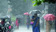 An Indian resident walks past under an umbrella during heavy monsoon rains in Chennai on November 30, 2017. AFP / Arun Sankar