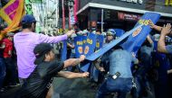 Activists scuffle with policemen during an anti-Duterte protest in Manila on November 30, 2017, denouncing the government's crackdown of activists and what they call US-backed Duterte dictartorship.  AFP / Noel Celis