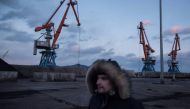 A Russian worker walking before cranes at Rajin's RasonConTrans coal port in North Korea. (Photo: AFP/Ed Jones).