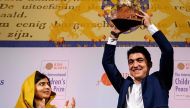 16-year old Syrian Mohamad Al Jounde (R) celebrates after receiving the International Children´s Peace Prize, given to him by Pakistani activist and Nobel Peace Prize laureate Malala Yousafzai on December 4, 2017 at the Ridderzaal in the Hague. Netherland