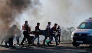 Palestinian protesters clash with Israeli troops near an Israeli checkpoint in the West Bank city of Ramallah on December 8, 2017. / AFP / ABBAS MOMANI