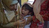 IMMUNIZATION. An Indonesian girl cries as she receives a vaccination shot against diphtheria at a village clinic in Jakarta on December 11, 2017. Adek Berry/AFP.