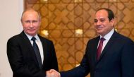 Russian President Vladimir Putin (L) shakes hands with his Egyptian counterpart Abdel Fattah al-Sisi upon his arrival at the presidential palace in the capital Cairo on December 11, 2017. / AFP / POOL / Alexander Zemlianichenko
