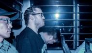 A file picture of British banker Rurik Jutting (2nd L), accused of the murders of two Indonesian women, sits in a prison van as he arrives at the eastern court in Hong Kong May 8, 2015. / AFP / ANTHONY WALLACE