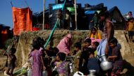 Rohingya refugees fill their containers with water at the Onchiprang refugee camp near Cox's Bazar, Bangladesh December 13, 2017. REUTERS/Alkis Konstantinidis.