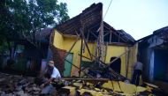 A man cleans up the wreckage of a house damaged by an earthquake in Sumelap Village, Tasikmalaya City, West Java, Indonesia December 16, 2017 in this photo taken by Antara Foto. / Reuters.
