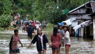 Villagers wade through a flooded street in Brgy Calingatngan, in Borongan, on easterm Samar in central Philippines on December 16, 2017. (AFP / ALREN BERONIO)