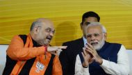 Indian Prime Minister and head of the Bharatiya Janata Party (BJP) Narendra Modi (R) and party president Amit Shah talk at the start of a speech at the party headquarters in New Delhi on December 18, 2017. (AFP / SAJJAD HUSSAIN)
